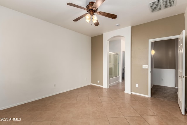 8848 W Cordes Rd, Tolleson, AZ 85353 - empty room featuring arched walkways, a ceiling fan, light tile patterned flooring, and baseboards