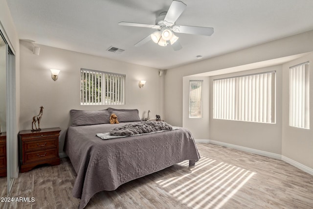 bedroom with ceiling fan, a closet, and light wood-type flooring