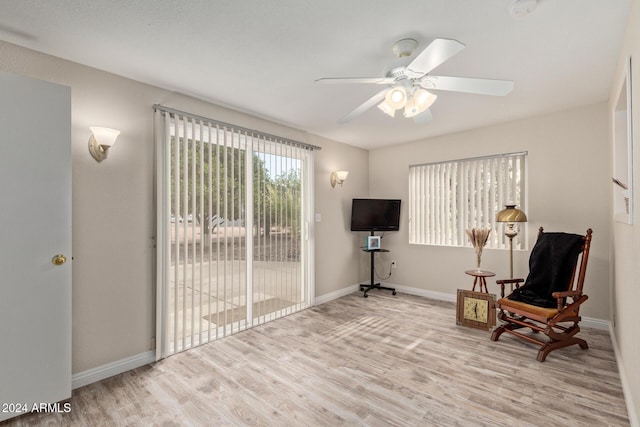 sitting room with ceiling fan and light wood-type flooring