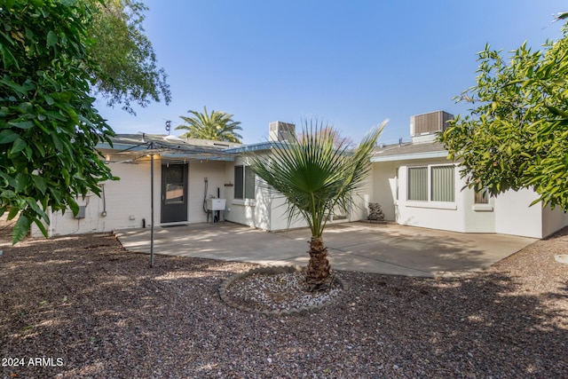 rear view of house with a patio area and central AC