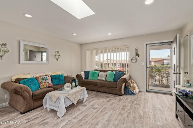 living room featuring a skylight and light hardwood / wood-style floors