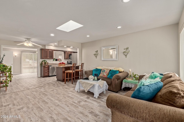 living room featuring ceiling fan and light hardwood / wood-style flooring