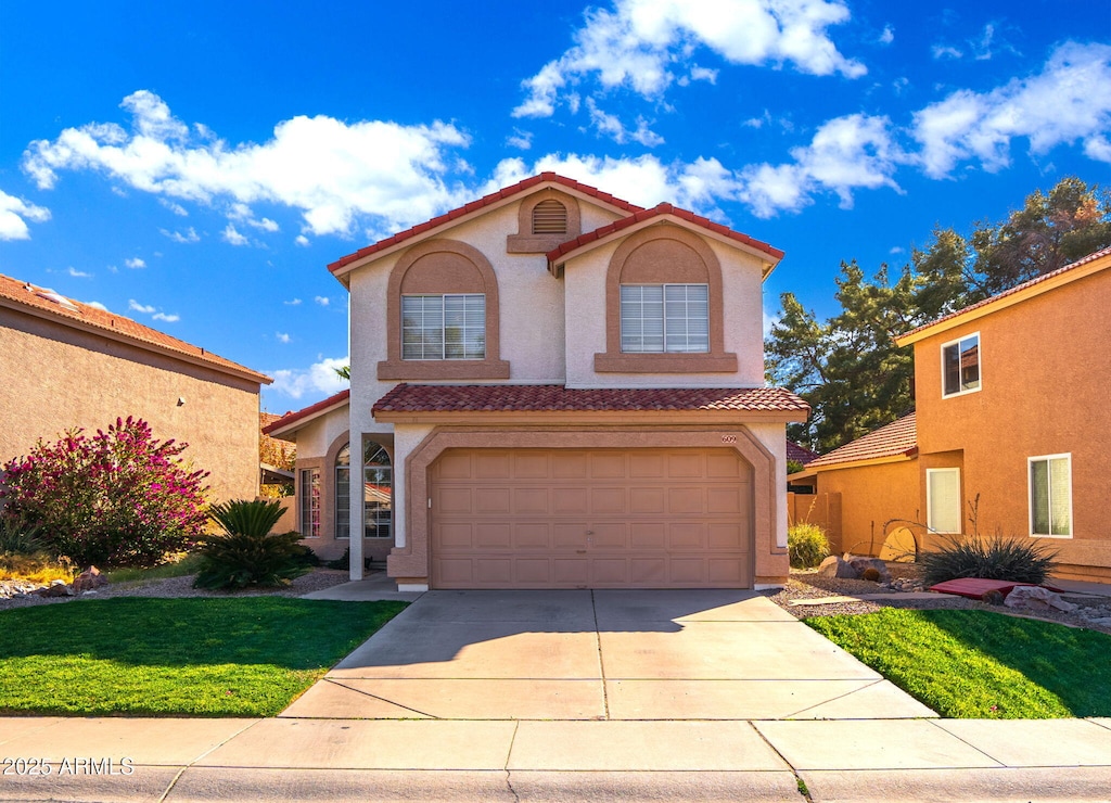 mediterranean / spanish home with a front lawn and a garage