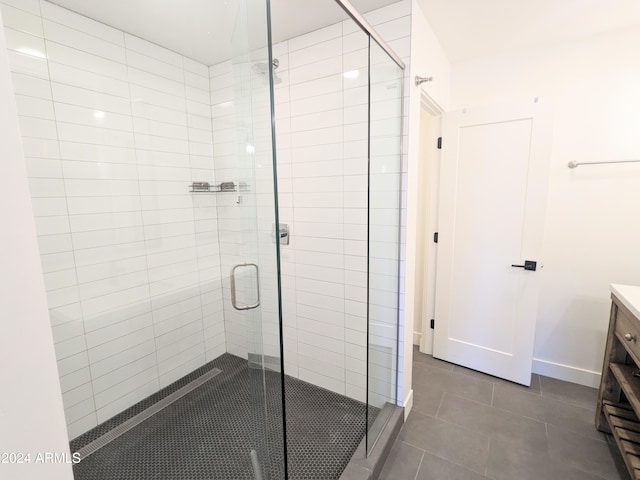 bathroom featuring vanity, a shower with shower door, and tile patterned flooring