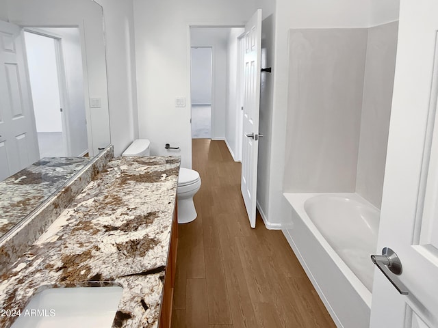 bathroom featuring hardwood / wood-style floors, vanity, toilet, and a bathing tub