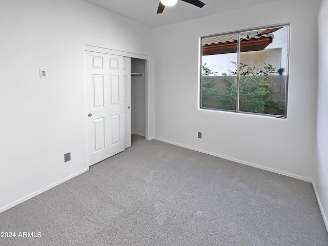 unfurnished bedroom featuring carpet flooring, ceiling fan, and a closet