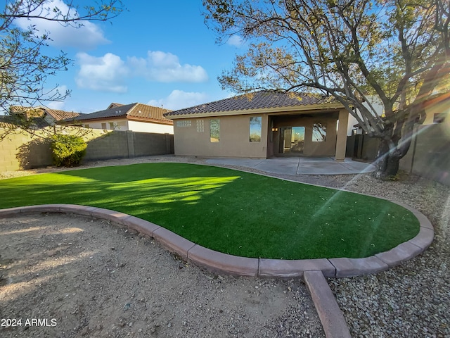 back of property featuring a yard and a patio