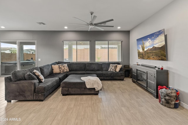 living room with light hardwood / wood-style flooring, ceiling fan, and plenty of natural light