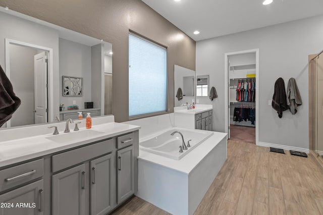 bathroom with vanity, plus walk in shower, and hardwood / wood-style floors