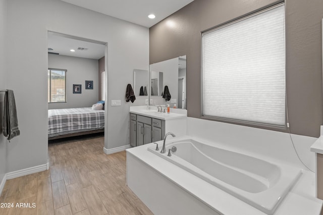 bathroom with vanity and a tub to relax in