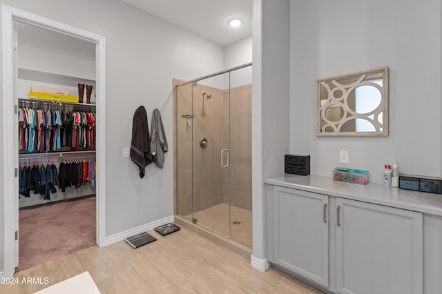 bathroom with hardwood / wood-style floors and an enclosed shower