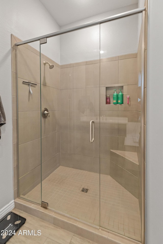 bathroom with tile patterned flooring and a shower with door