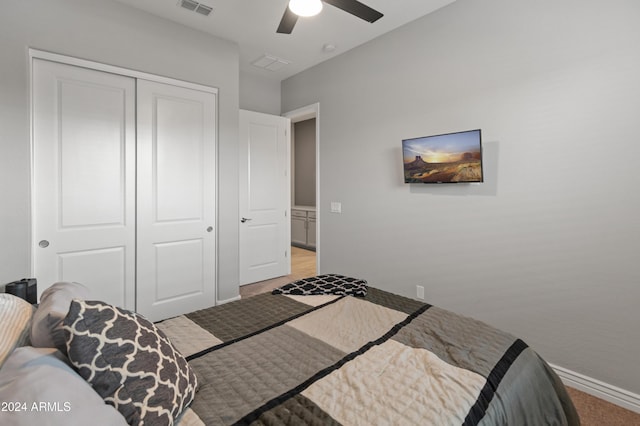 bedroom featuring light carpet, ceiling fan, and a closet