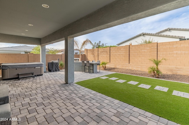 view of patio with a hot tub and an outdoor bar