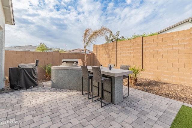 view of patio / terrace featuring area for grilling, a grill, and exterior bar