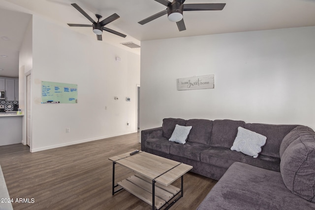 living room featuring ceiling fan, dark hardwood / wood-style floors, and vaulted ceiling