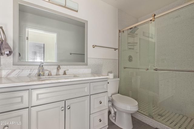 bathroom with vanity, a shower with shower door, and toilet