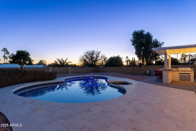 pool at dusk featuring an outdoor bar, area for grilling, and a patio area