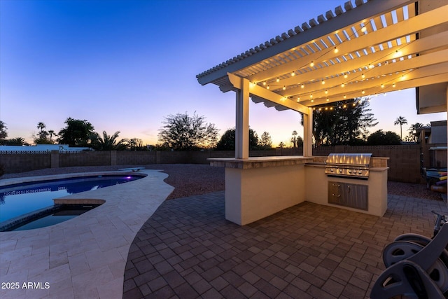 patio terrace at dusk with an outdoor kitchen, a pergola, a grill, and a fenced in pool