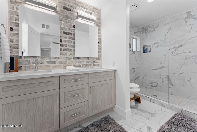 bathroom with a tile shower, vanity, and toilet