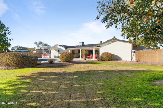 back of property featuring a lawn, a swimming pool, and a patio area