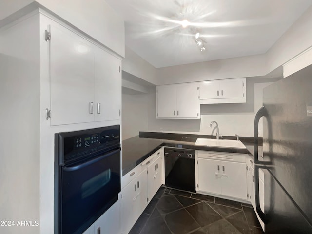 kitchen featuring white cabinetry, sink, black appliances, and dark tile patterned floors