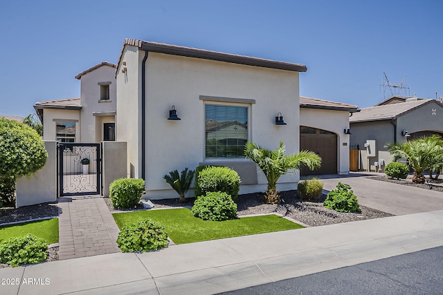 199 E Tangerine Path, Queen Creek, AZ 85140 - view of front of house featuring an attached garage, a gate, stucco siding, concrete driveway, and a tiled roof