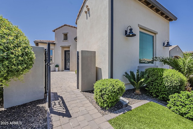 199 E Tangerine Path, Queen Creek, AZ 85140 - view of side of home with stucco siding, a gate, and a tiled roof