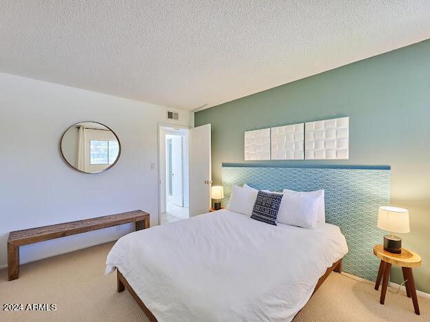 carpeted bedroom with a textured ceiling