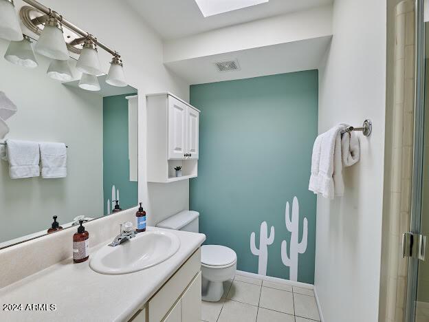 bathroom featuring walk in shower, tile patterned floors, vanity, and toilet