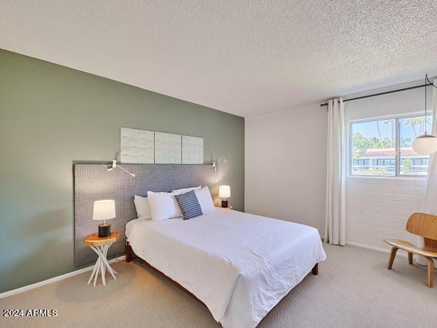 bedroom featuring a textured ceiling and carpet floors