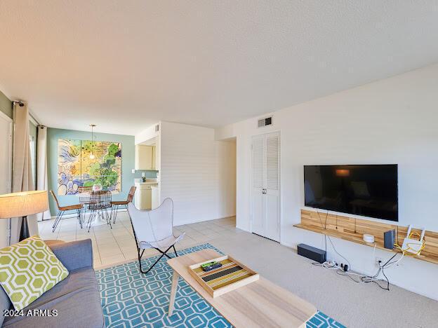 living room with a notable chandelier and light tile patterned flooring