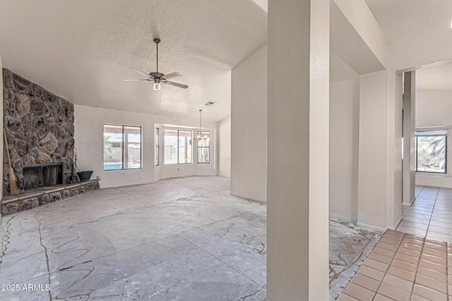 6032 W Grovers Ave, Glendale, AZ 85308 - unfurnished living room with plenty of natural light, a fireplace, a ceiling fan, a textured ceiling, and vaulted ceiling
