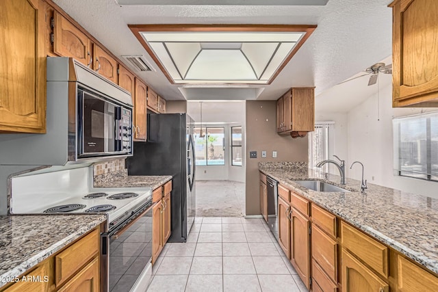 6032 W Grovers Ave, Glendale, AZ 85308 - kitchen featuring stainless steel appliances, a sink, brown cabinetry, light tile patterned floors, and light stone countertops