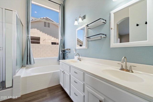 full bathroom with a sink, wood finished floors, and a shower stall