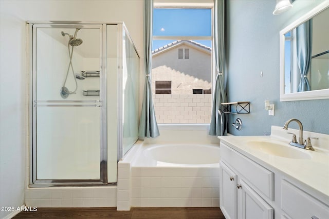 bathroom featuring a garden tub, a healthy amount of sunlight, a stall shower, and vanity