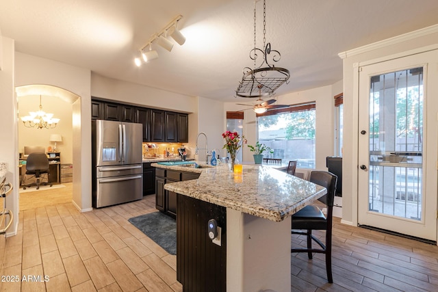 288 W Los Alamos St, Gilbert, AZ 85233 - kitchen featuring stainless steel refrigerator with ice dispenser, a sink, a chandelier, a breakfast bar, and light wood-type flooring