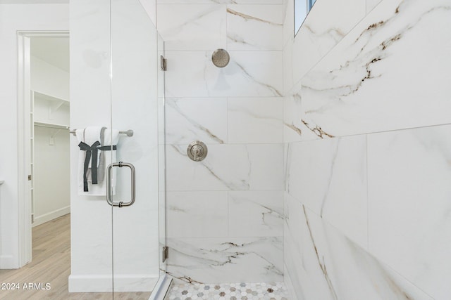 bathroom featuring a shower with shower door and hardwood / wood-style floors