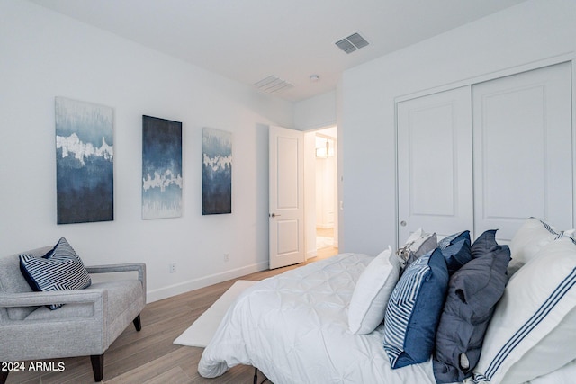 bedroom with light hardwood / wood-style floors and a closet