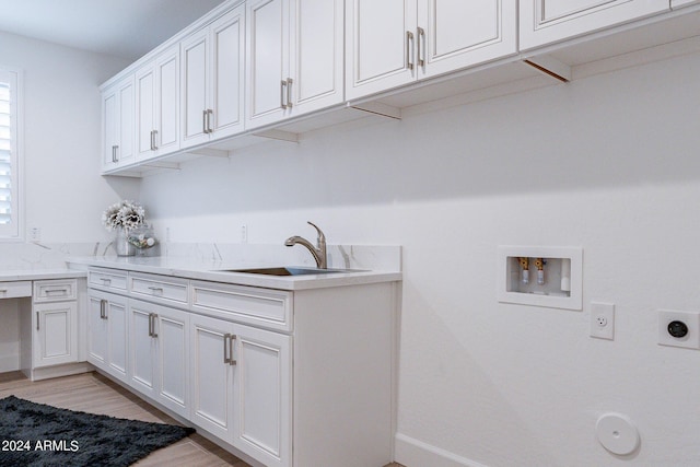 laundry room with light wood-type flooring, cabinets, hookup for an electric dryer, sink, and washer hookup