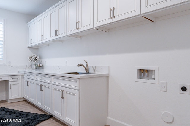 washroom featuring light hardwood / wood-style floors, sink, washer hookup, cabinets, and hookup for an electric dryer