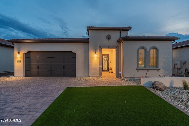 mediterranean / spanish-style house featuring a garage and a lawn