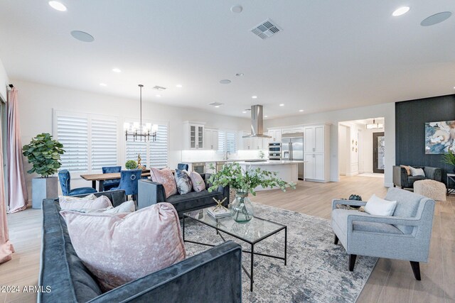 dining room with sink, a notable chandelier, and light hardwood / wood-style floors