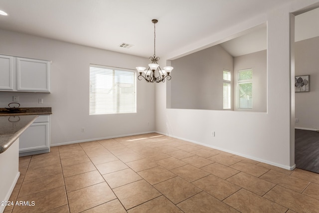 unfurnished dining area featuring a notable chandelier and light tile patterned flooring