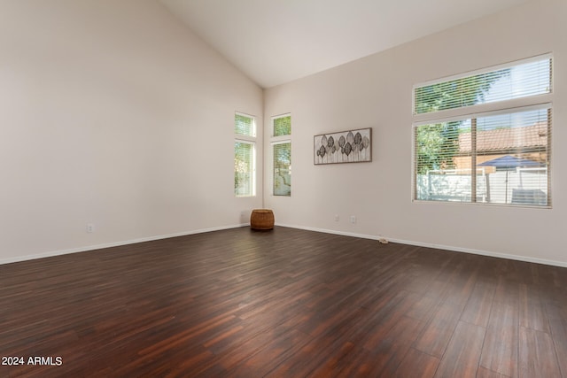 unfurnished room featuring dark wood-type flooring, plenty of natural light, and high vaulted ceiling