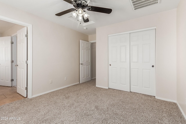 unfurnished bedroom with ceiling fan, light colored carpet, and a closet