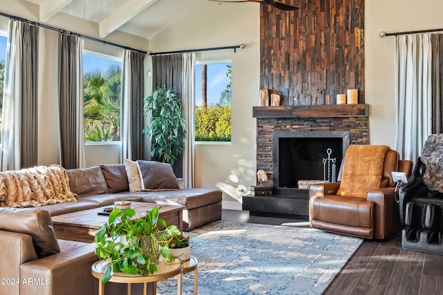 living room featuring a stone fireplace, beamed ceiling, dark wood-type flooring, and high vaulted ceiling