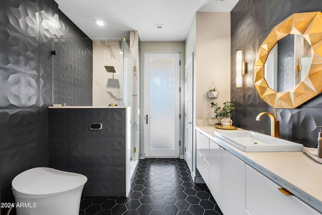 bathroom featuring toilet, vanity, tile patterned floors, and tile walls