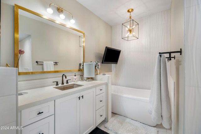 bathroom with a bathtub, vanity, and a chandelier