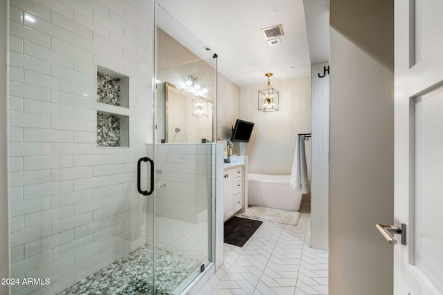 bathroom featuring plus walk in shower, vanity, and tile patterned floors